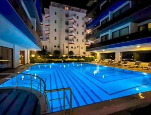 a large swimming pool in a building at night at The Blue Tide - 1 Bedroom Apartment - All Bills Included in Alanya