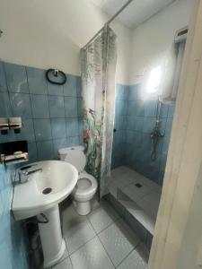 a bathroom with a toilet and a sink and a shower at Mpita 2 in Pointe-Noire +4 photos