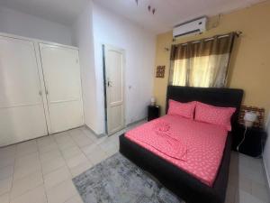 a bedroom with a bed with pink pillows on it at Mpita 2 in Pointe-Noire