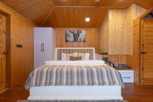 a bedroom with a bed in a room with wooden walls at Megha Resort & Villas, Dehradun-Where Nature Pampers You in Dehradun +47 photos
