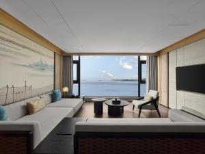 a living room with a couch and a tv at 珠海凤凰湾悦榕庄 in Zhuhai