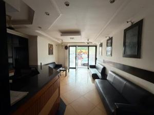 a waiting room with black leather couches in a building at Downtown in Manipala