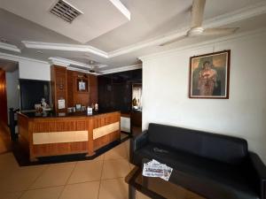 a lobby with a reception desk and a couch at Downtown in Manipala