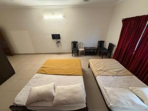 マニパルにあるDowntownのベッド2台とテーブルと椅子のある部屋