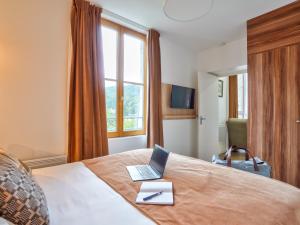 ビュール・シュリヴェットにあるResidhome Paris Saclay " Bures sur Yvette "のベッドルーム1室(ベッド1台にノートパソコン付)