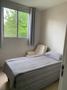 a bedroom with a bed and a window at Calmo e aconchegante apartamento térreo com quintal in Valparaíso de Goiás