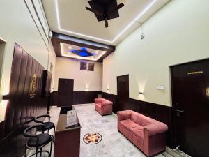 a waiting room with pink chairs and a ceiling at Shree Balaji Comfort - Free Parking in Varanasi