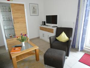 a living room with a chair and a television at Ferienwohnung Stella Fiante in Juliusruh