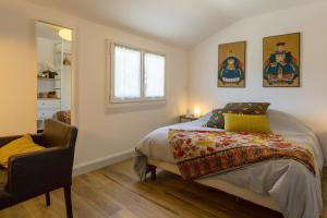 a bedroom with a bed and a chair and a window at Maison Coz Campagne Calme Piscine in Clohars-Fouesnant +24 photos