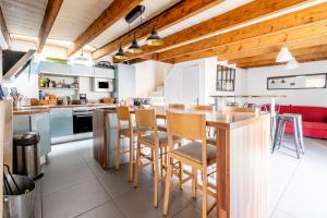 une cuisine avec une table et des chaises en bois dans l'établissement Maison familiale sud Nantes, à Bouguenais