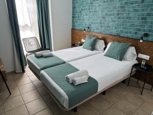 two beds in a room with green and white at HOTEL ORENETA - Gironella in Gironella +11 photos