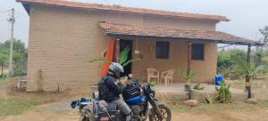 un homme qui fait une moto devant une maison dans l'établissement Shivalika home stay, à Maheshwar 5 autres photos