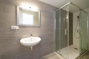 トレ・デ・ベナガルボンにあるDreamy Beach Duplexの洗面台とガラスのシャワーを備えたバスルーム