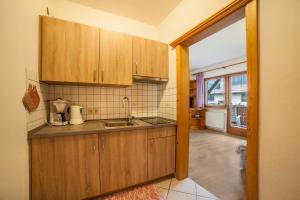 a kitchen with wooden cabinets and a sink at Sonnenparadies Apartement 1 in Saltusio +14 photos
