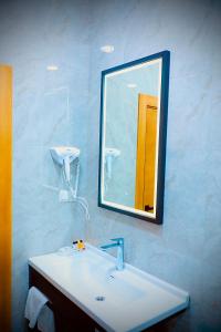 a bathroom with a sink and a mirror at Loren Hotel in Tashkent