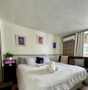 a bedroom with a large white bed with towels on it at Isla Verde Serenity by the Sea in San Juan