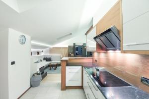 una cucina con mobili bianchi e un soggiorno di Apt Hetti - Haus Kostner a Santa Cristina in Val Gardena