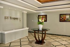 a vase of flowers on a table in a room at Isla Verde Serenity by the Sea in San Juan +14 photos