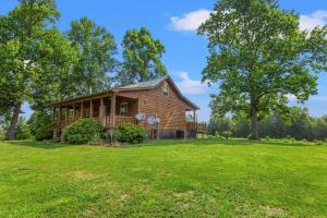 a house on a green field with trees at Heavenly Hideaway - near Red River Gorge KY in Beattyville