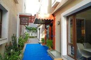 - un couloir dans un bâtiment doté d'un tapis bleu dans l'établissement Rosse Dale Suites and Hotel Coimbatore, à Coimbatore