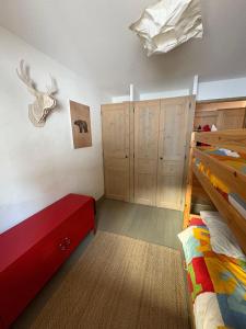 a bedroom with a bed and some wooden cabinets at les 7 laux immobilier chalet D in Prapoutel
