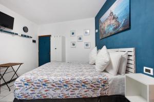 une chambre avec un lit avec un mur bleu dans l'établissement Ca Du Grifun 2, à Vernazza