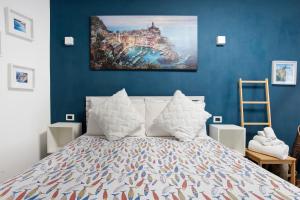 une chambre avec un lit avec un tableau sur le mur dans l'établissement Ca Du Grifun 2, à Vernazza 16 autres photos