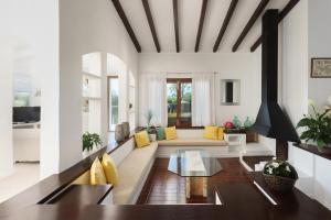 een woonkamer met een bank en een tafel bij Playa in Port de Pollença