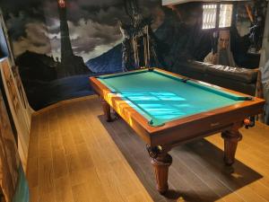 a pool table in a room with a painting at La Comté à Blagnac in Blagnac