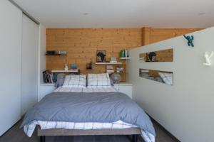 a bedroom with a bed and wooden walls at La Tour 74 in Thônes