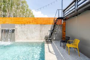 ein Swimmingpool mit zwei Stühlen und einem Tisch in der Unterkunft Cactus Villa 2024, Krabi in Klong Muang Beach