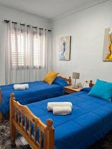 Dos camas en un dormitorio con sábanas azules. en Casa del Molino, en Icod de los Vinos