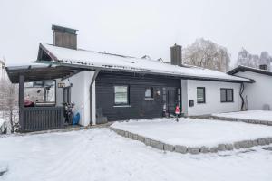 a house with a snow covered yard in front of it at In Bayern in Warngau
