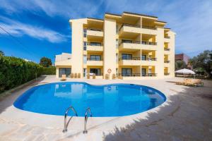 a building with a large swimming pool in front of a building at Apto con Terraza 403 in Cala Millor
