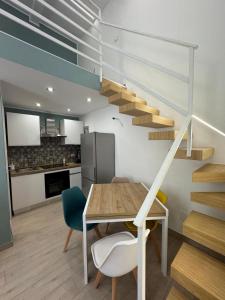 a kitchen and a dining room with a table and stairs at AparthouseRisorgimento CANAPA in Frattamaggiore