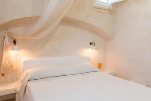 a bedroom with a white bed with a ceiling at Bilocale 103-tia Maria Country Inn in Racale