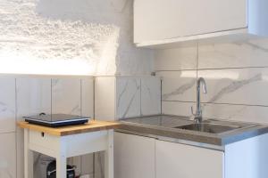 a white kitchen with a sink and a counter at La Porta Sul Mare- Timone in Mola di Bari +10 photos