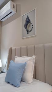 a bed with a headboard with two pillows on it at Appartement Cocooning de Sousse in Hammam Sousse