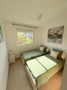 a bedroom with two beds and a window at Bright apartment with sea view in Casares, 96 m², pool in Casares