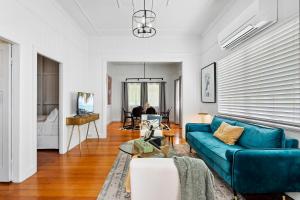 ein Wohnzimmer mit einem blauen Sofa und einem Tisch in der Unterkunft Wandal Haven On McKelligett 1 King 2 Doubles -Wifi 