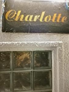 a sign that reads chantolittle with a window at Charlotte Inn in Kandy