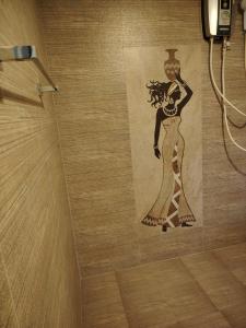 a painting of a woman on the wall of a bathroom at Charlotte Inn in Kandy