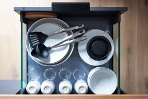 a cabinet filled with dishes and utensils at Alte Seifensiederei - Jane in Bad Tölz +11 photos