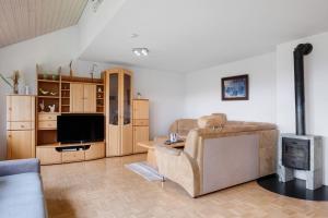 uma sala de estar com um sofá e uma televisão em Grundhof Christian Faller em Stegen