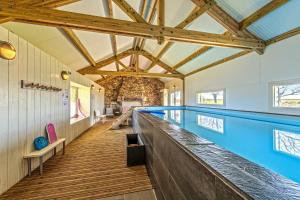 a swimming pool in a house with wooden ceilings at Gîte avec piscine privée chauffée in Plouguerneau