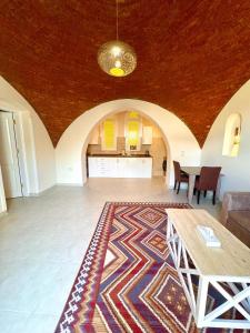 a living room with a table and a rug at Royal Home Dome Style - Ground Floor Apartment in Jazīrat al ‘Awwāmīyah
