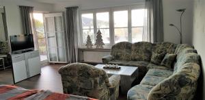 a living room with a couch and chairs and a tv at Ferienwohnung Breit - Kirchdorf in Kirchdorf im Wald