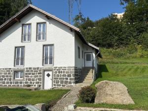 a white house with a rock in front of it at Landhaus am Burgberg in Freyung