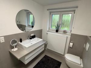 a white bathroom with a sink and a mirror at Landhaus am Burgberg in Freyung +10 photos