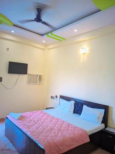 a bedroom with a bed with a ceiling fan at Hotel Pleasure Inn in Prayagraj